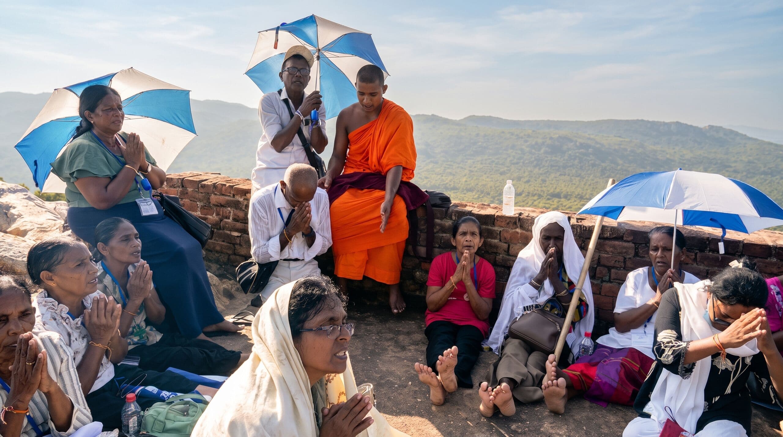 Lakdiva pilgrims in worship with a monk on the Vulture's Peak, Rajgir